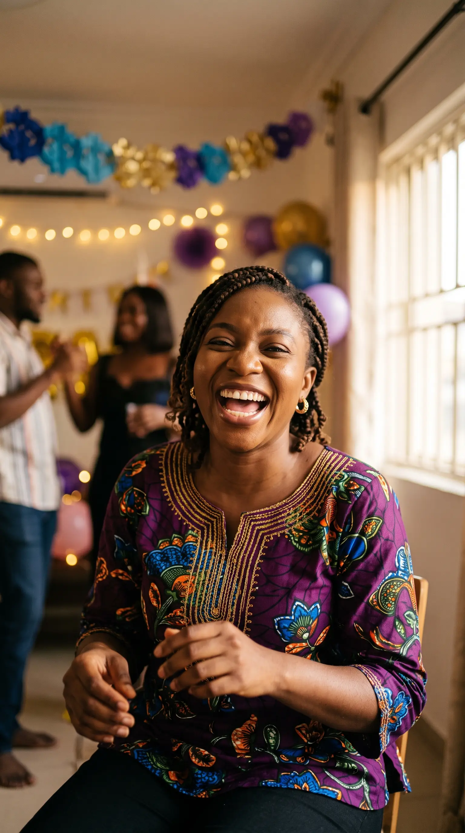 A woman laughing on her birthday, friends behind her in a decorated room